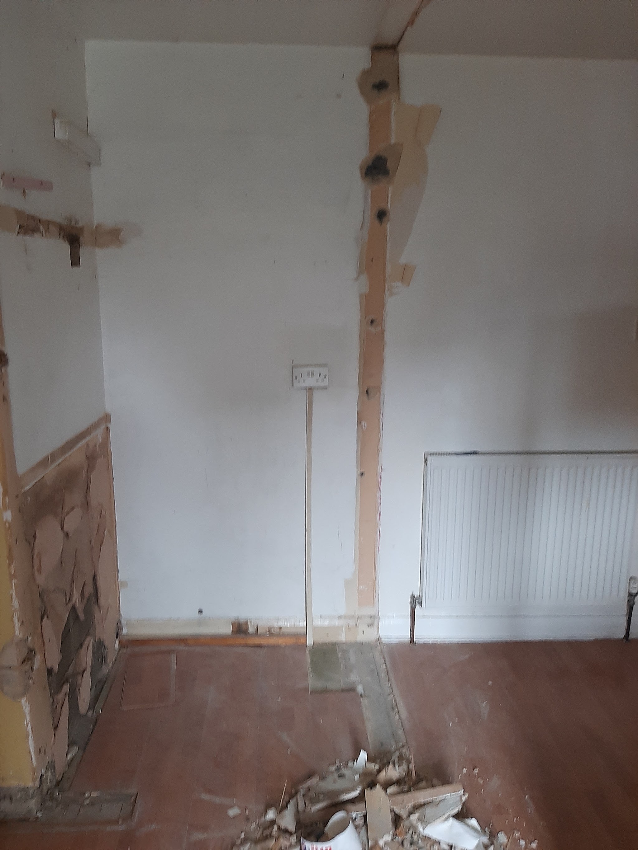 A room stripped back to bare walls and boards before the work starts