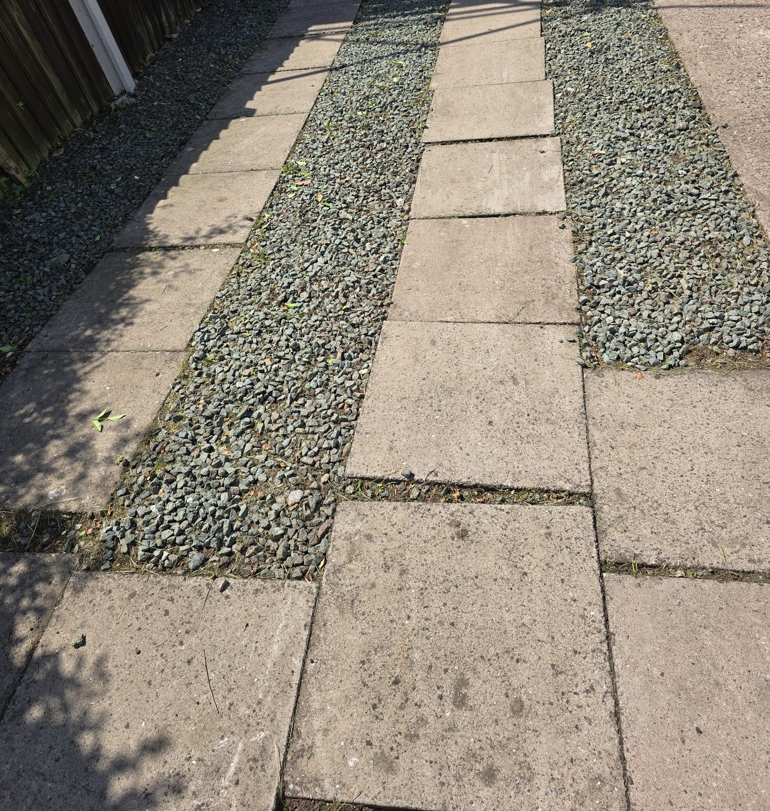 Paving slabs laid in strips with grey gravel between them
